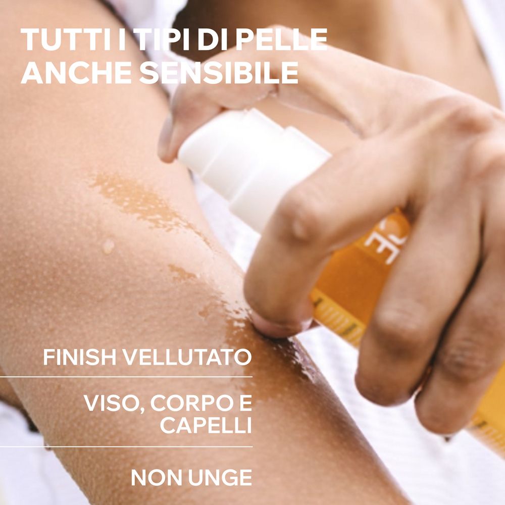 Persona che spruzza olio sul braccio. Testo: Tutti i tipi di pelle, anche sensibili. Finish vellutato. Viso, corpo, capelli. Non unge.
