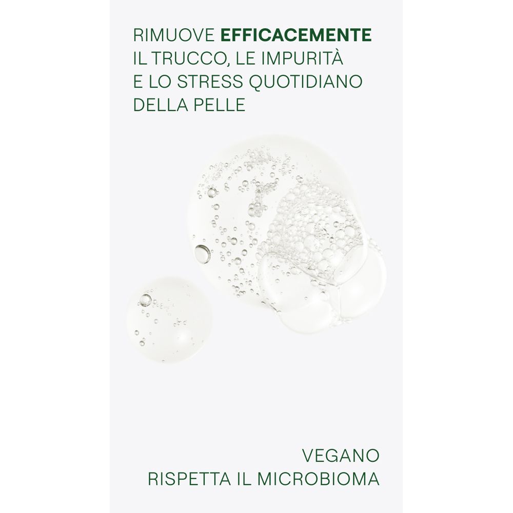 Primo piano di gocce di liquido trasparente. Testo: Rimuove efficacemente trucco, impurità e stress. Vegano.