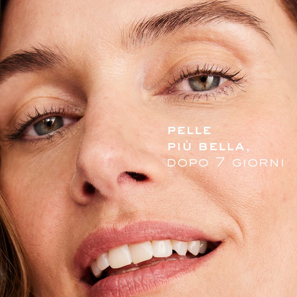 Primo piano di un viso sorridente. Testo: Pelle più bella, dopo 7 giorni.
