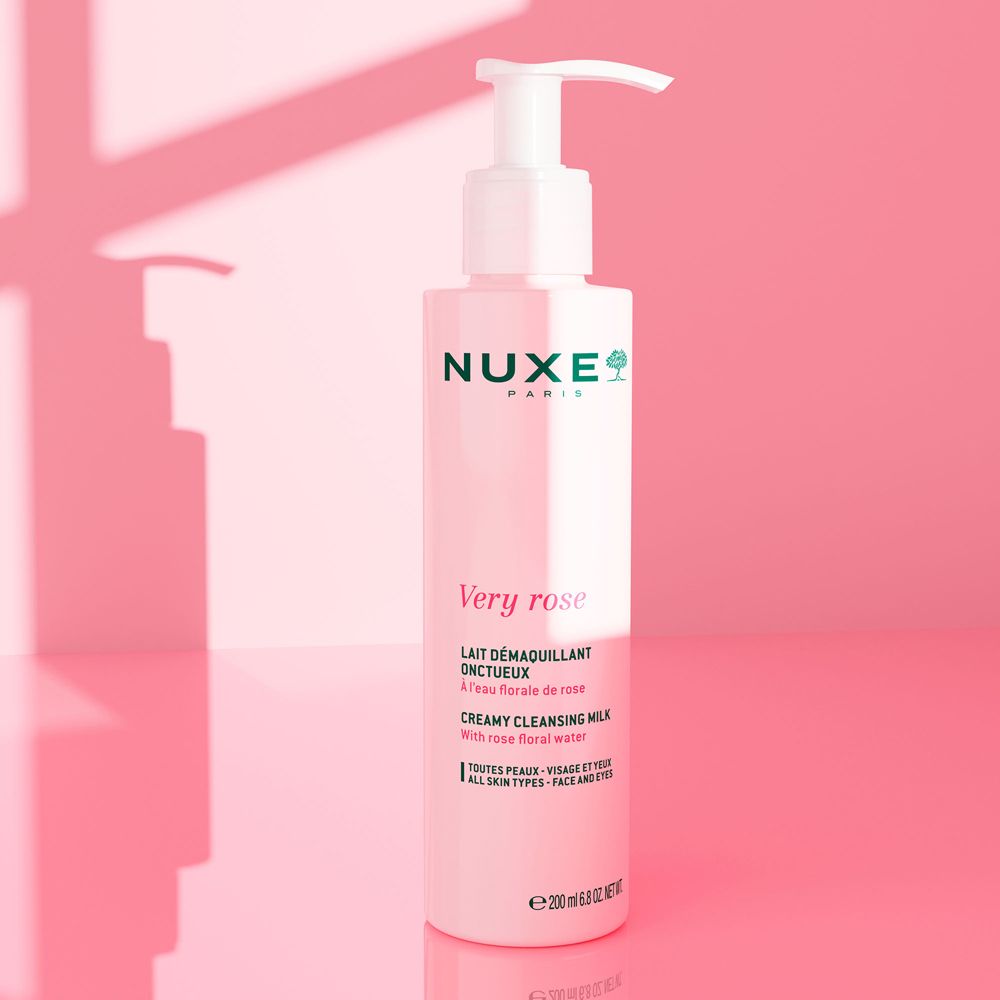 Flacone rosa con dosatore. Scritta: Nuxe Paris, Very Rose, Lait Démaquillant Onctueux, 200 ml. Sfondo rosa.