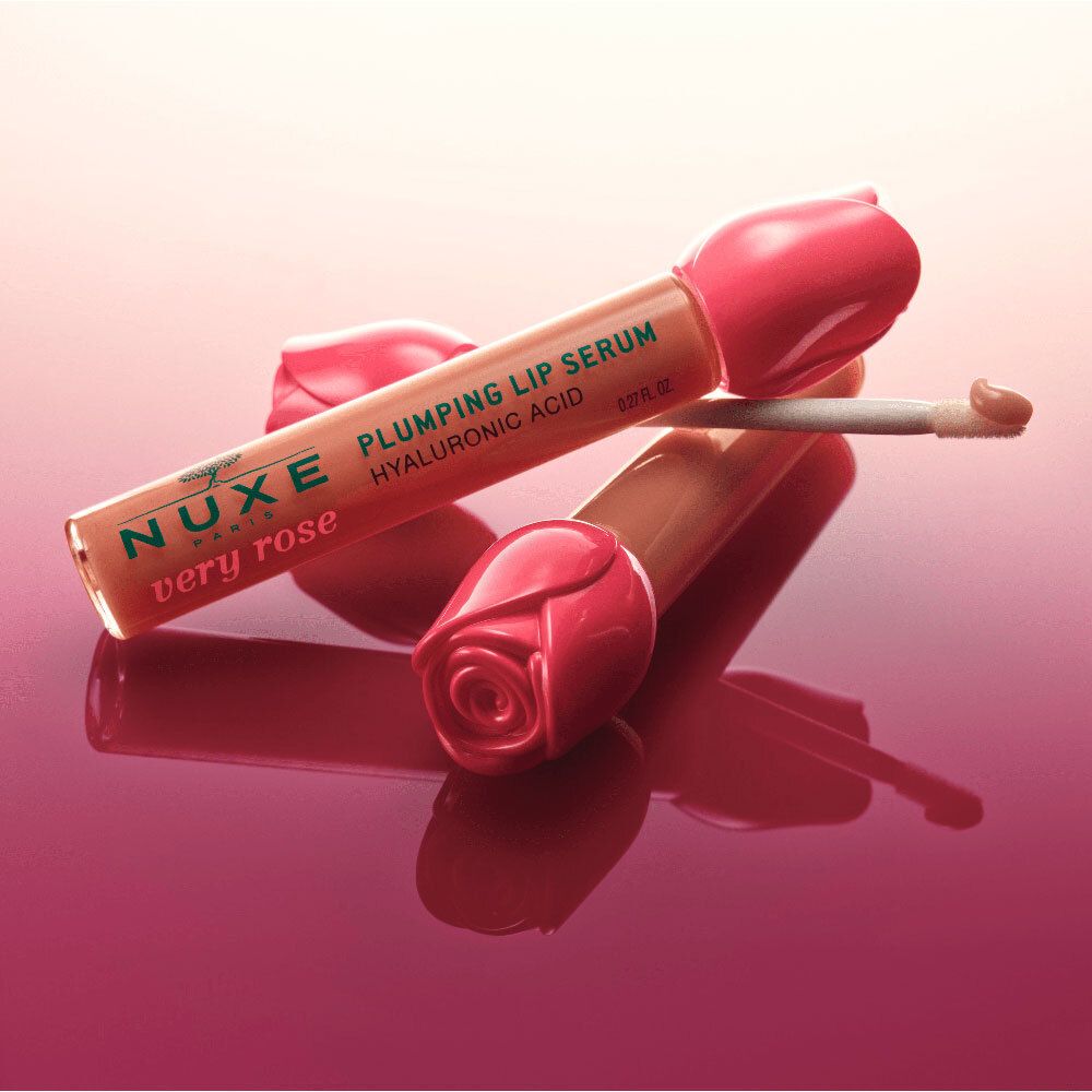 Due sieri labbra con tappo a tulipano rosa. Scritta: Nuxe Very Rose, Plumping Lip Serum, Acido Ialuronico. Superficie riflettente.