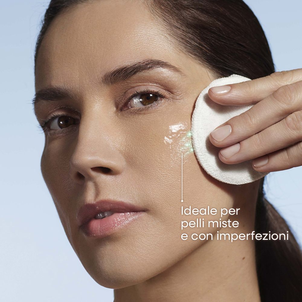 Donna pulisce il viso con dischetto di cotone e acqua micellare OMIA BIOTECH.