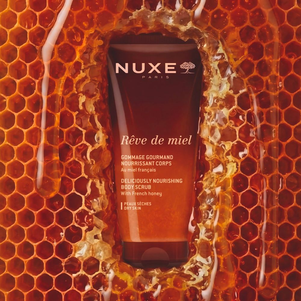 Tubo NUXE Rêve de miel scrub corpo circondato da favi e miele liquido.