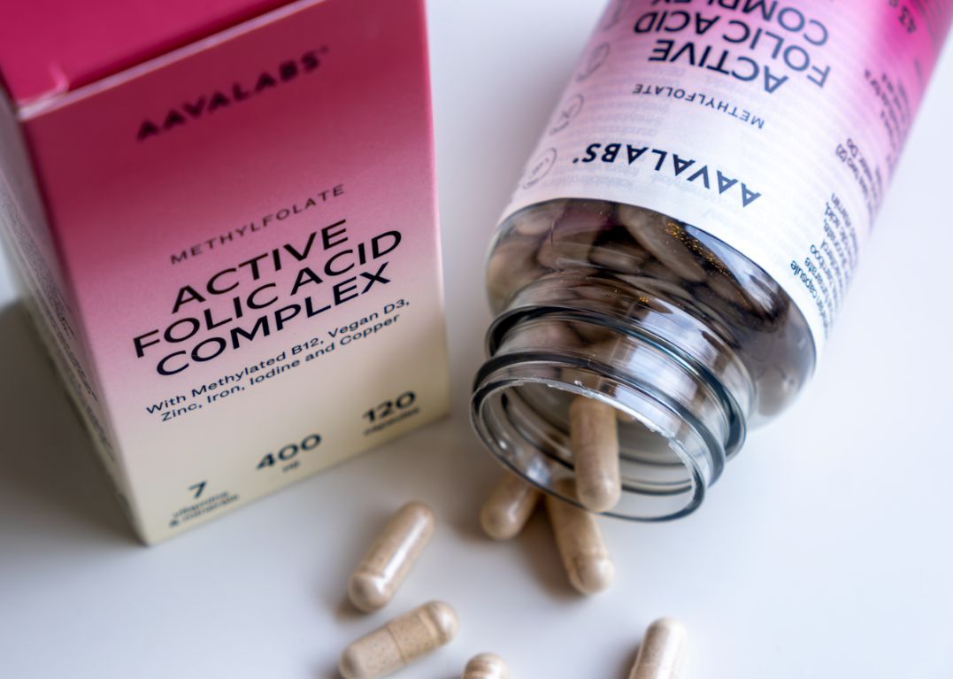 Capsule di complesso di acido folico Aavalabs accanto a flacone aperto e scatola.