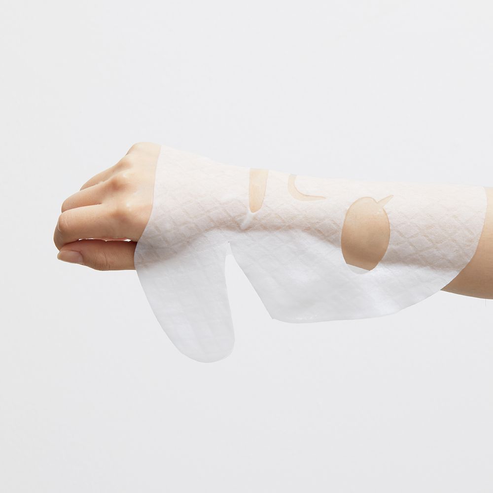 Maschera facciale bianca su una mano. Fori per occhi e bocca. La maschera ha un motivo.