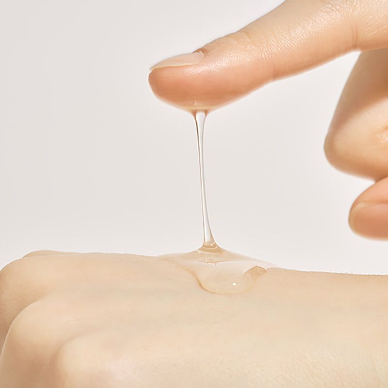 Primo piano di una mano. Il siero gocciola da un dito. Liquido trasparente.