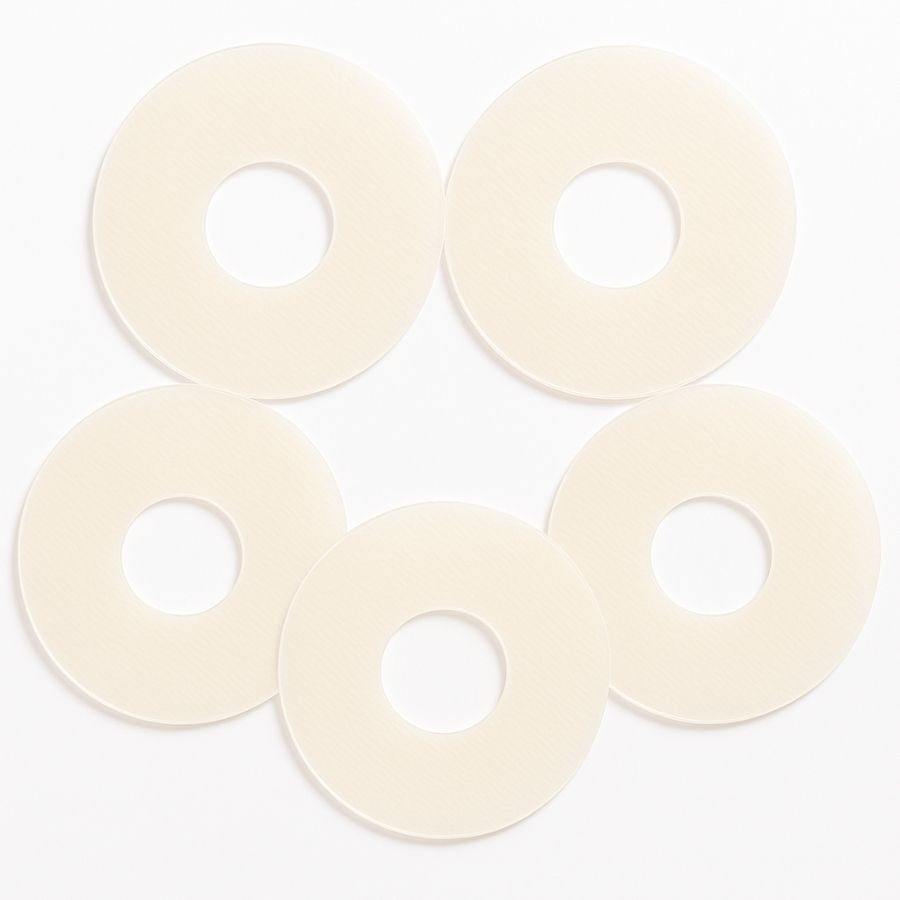 Cinque cerotti circolari beige in silicone con foro centrale, disposti a forma di petali.