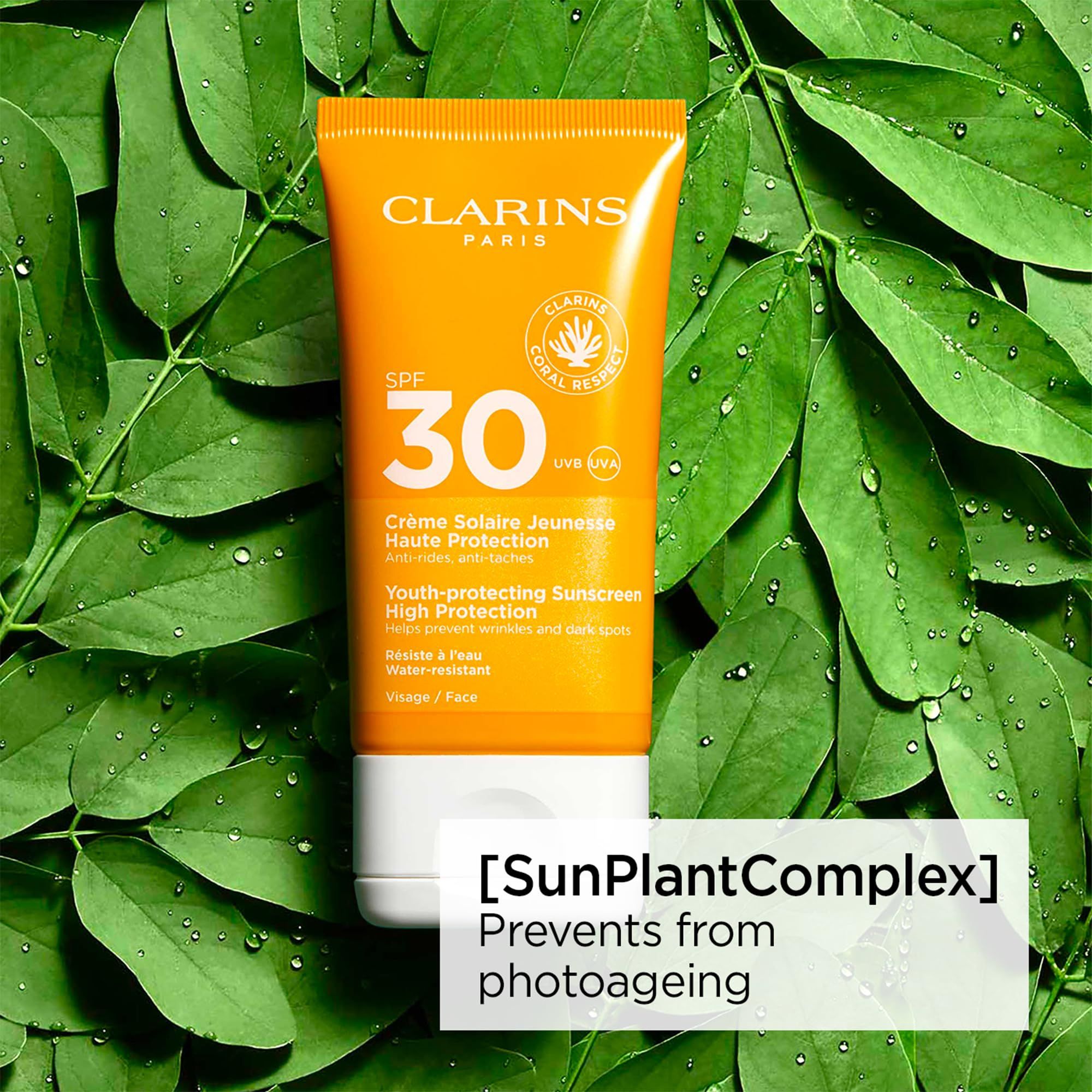 Tubo giallo con tappo bianco su foglie verdi. Scritta: Clarins, SPF 30, Crème Solaire Jeunesse, Haute Protection. Testo: [SunPlantComplex].