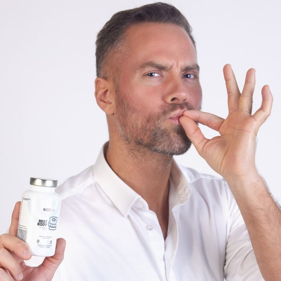 Uomo tiene flacone bianco, tappo argento. Scritta: BEST LAB BEST BODY. Mima di prendere una capsula.