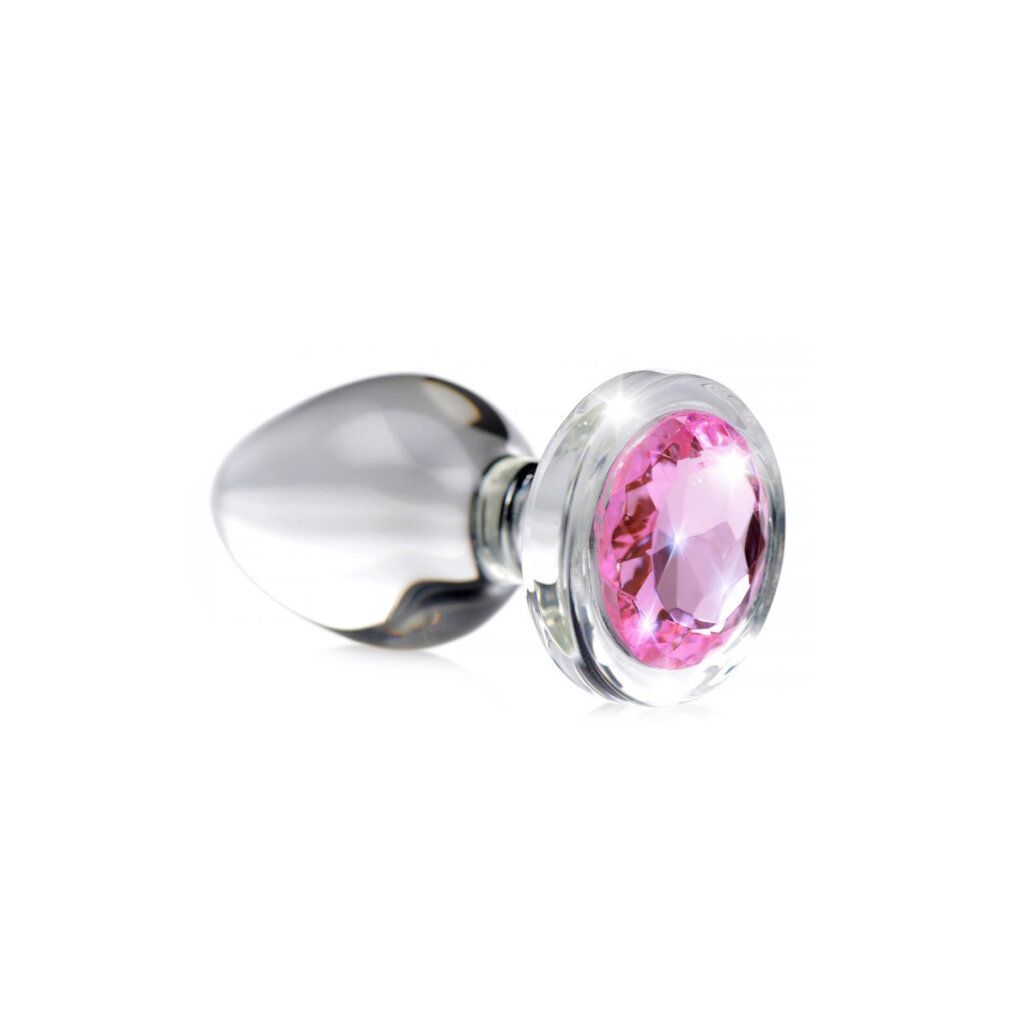 Plug anale in vetro con gemma rosa. Stelo trasparente, testa rotonda con pietra rosa. Su sfondo bianco.