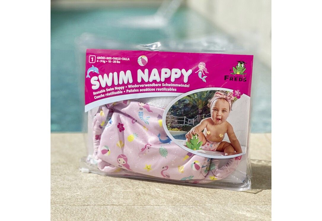 Confezione con pannolino da bagno rosa. Scritta: Swim Nappy, sirena, logo rana. Bambino in foto.
