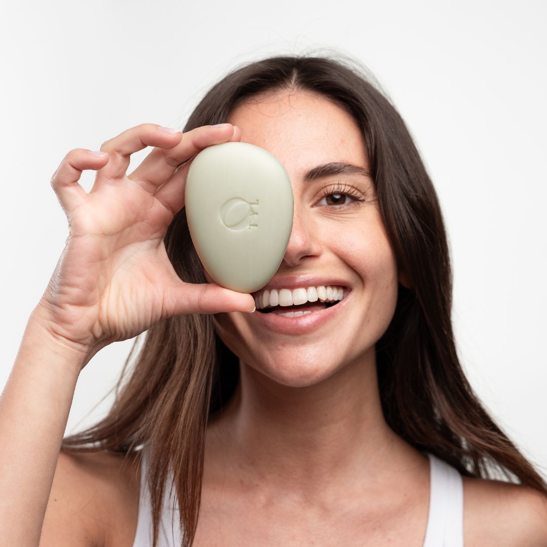 Sapone ovale chiaro davanti a un occhio. Donna sorridente. Sapone con logo.