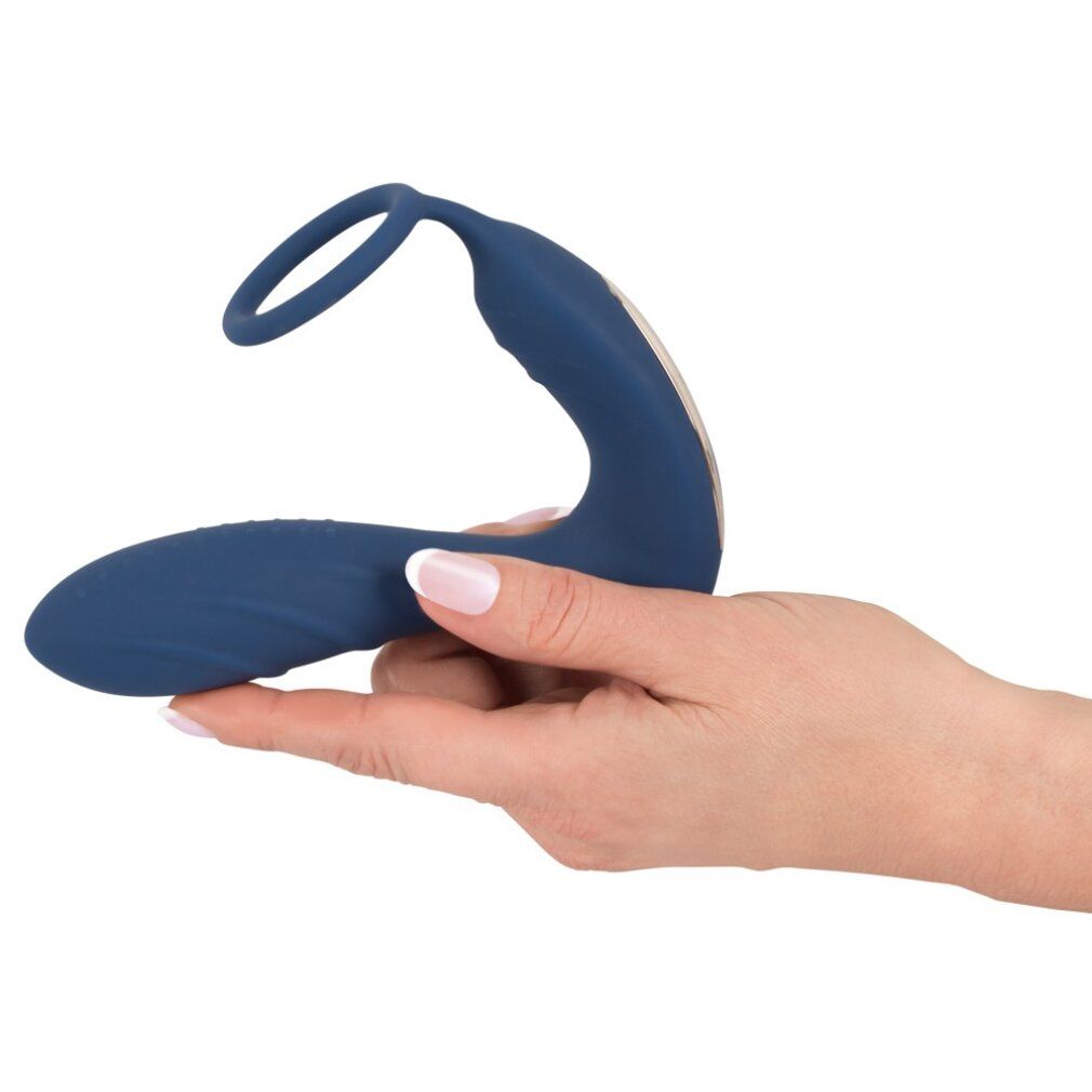 Plug anale blu con anello per il pene e stimolatore perineale, tenuto in mano. Forma curva.