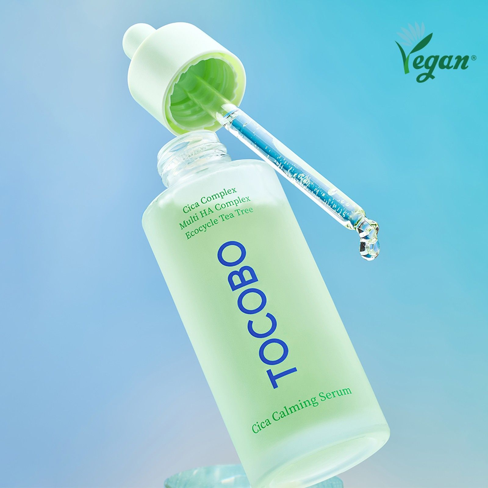 Flacone di siero lenitivo Cica Tocobo con contagocce. Sigillo vegano in alto a destra. Liquido blu gocciola dal contagocce.