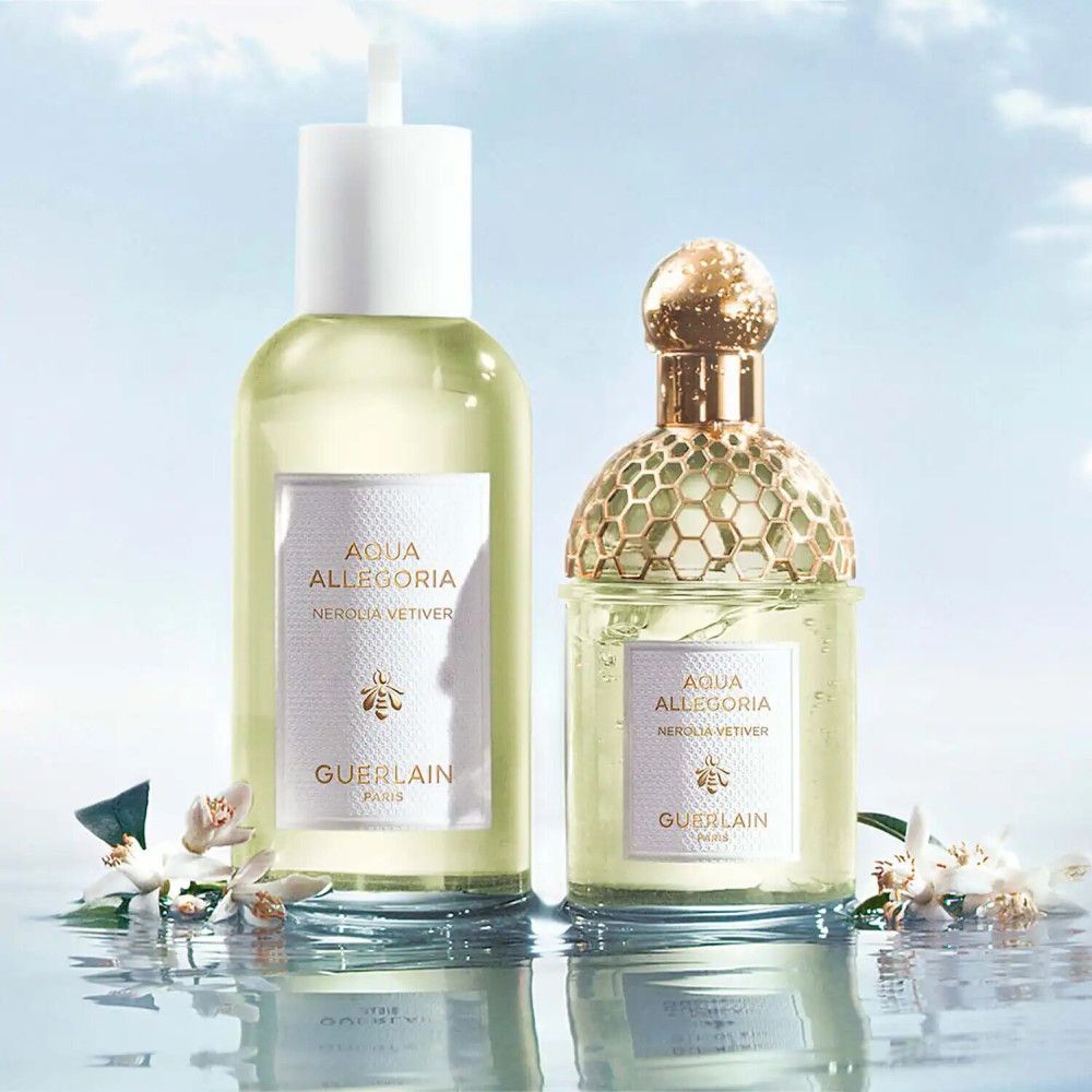Due flaconi di profumo, uno con vaporizzatore, uno con tappo dorato. Etichette con testo: Aqua Allegoria Nerolia Vetiver, Guerlain.