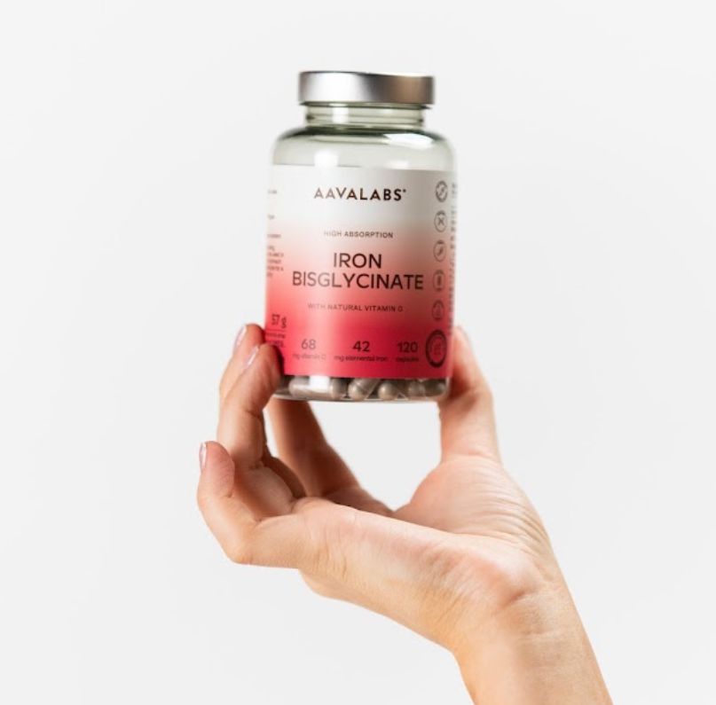 Mano che tiene una bottiglia di capsule Aavalabs Ferro Bisglicinato.