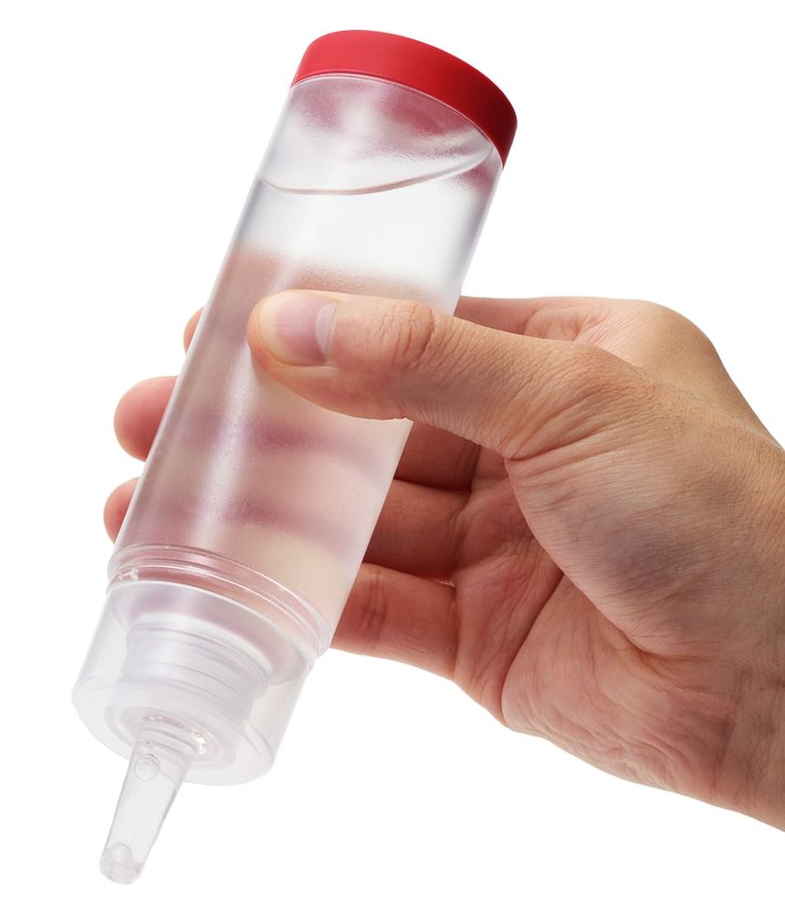 Mano che tiene una bottiglia trasparente di Tenga Hole Lotion Regular con tappo rosso.