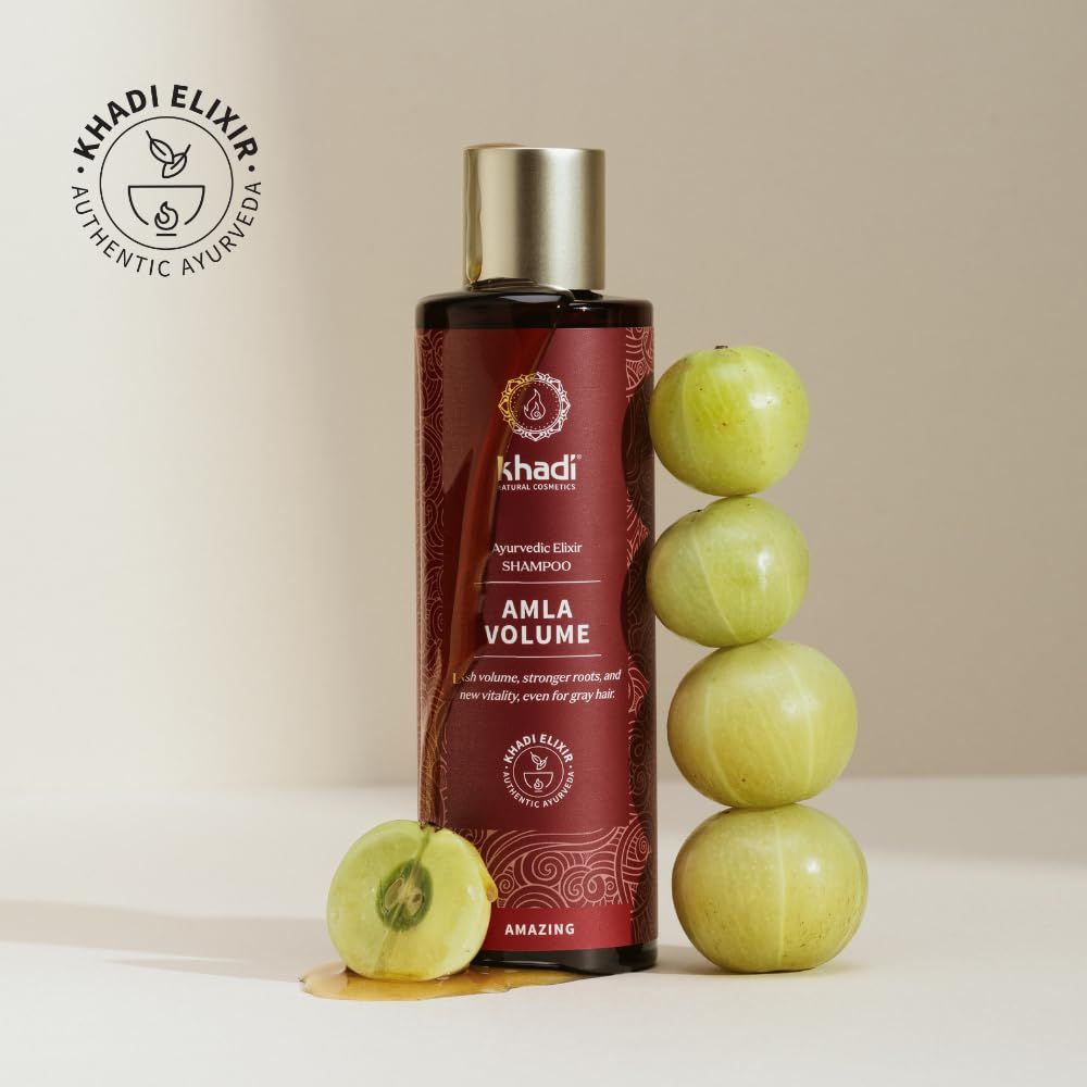 Flacone marrone con nome e logo del prodotto. Testo: Amla Volume. Frutta verde accanto. Logo: Khadi Elixir.