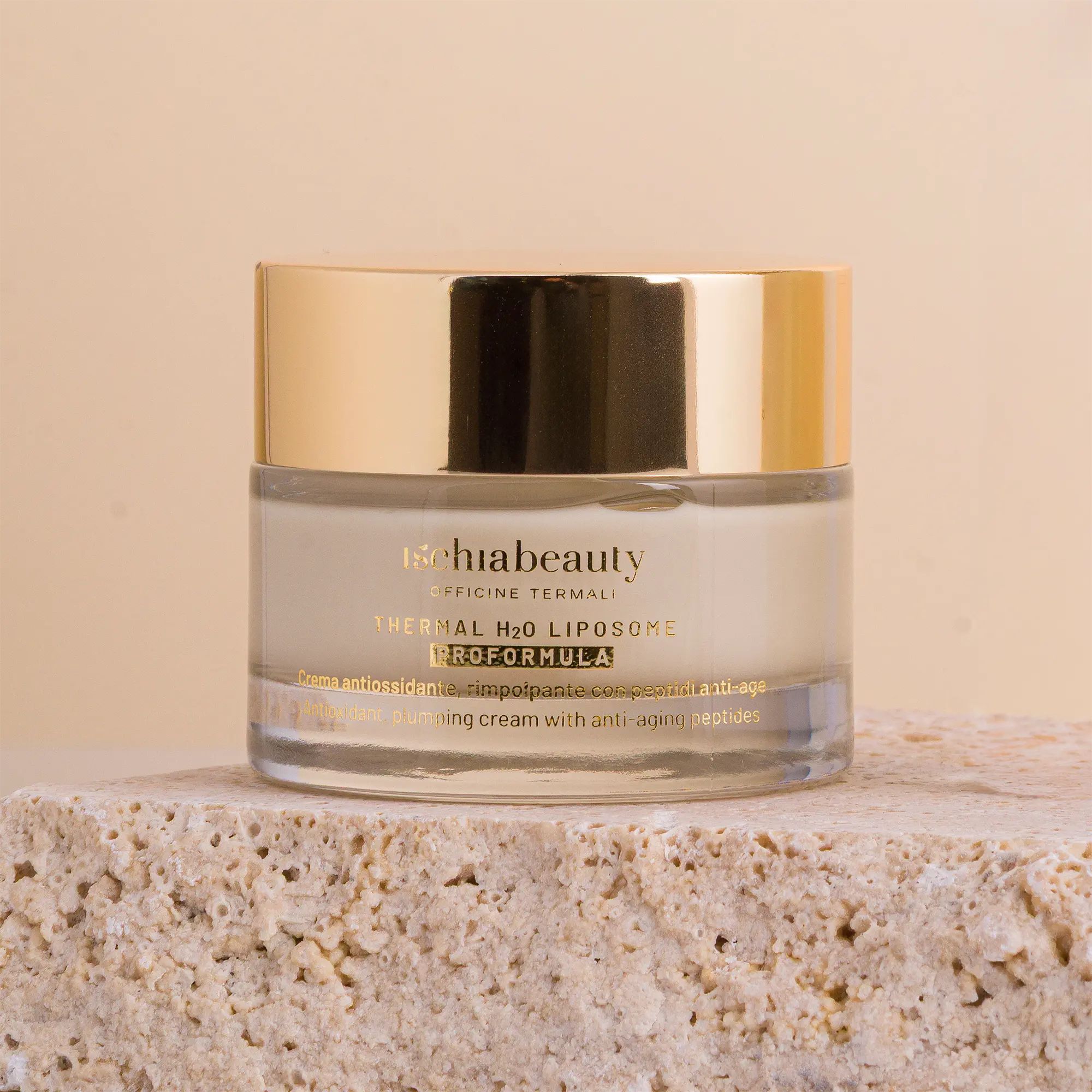 Vasetto di crema con coperchio dorato. Su pietra. Scritta del prodotto: Ischiabeauty, Thermal H2O Liposome Proformula.