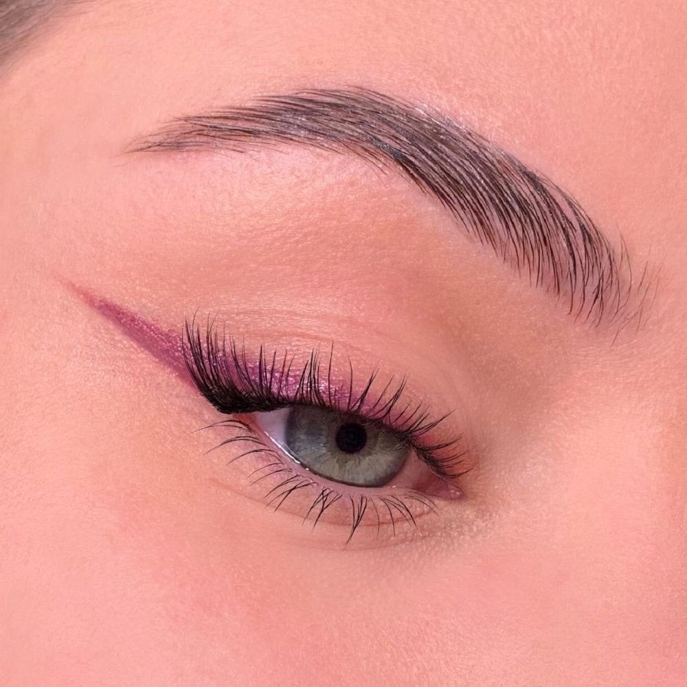 Occhio con eyeliner viola. Sopracciglio. Ciglia. Tono della pelle.