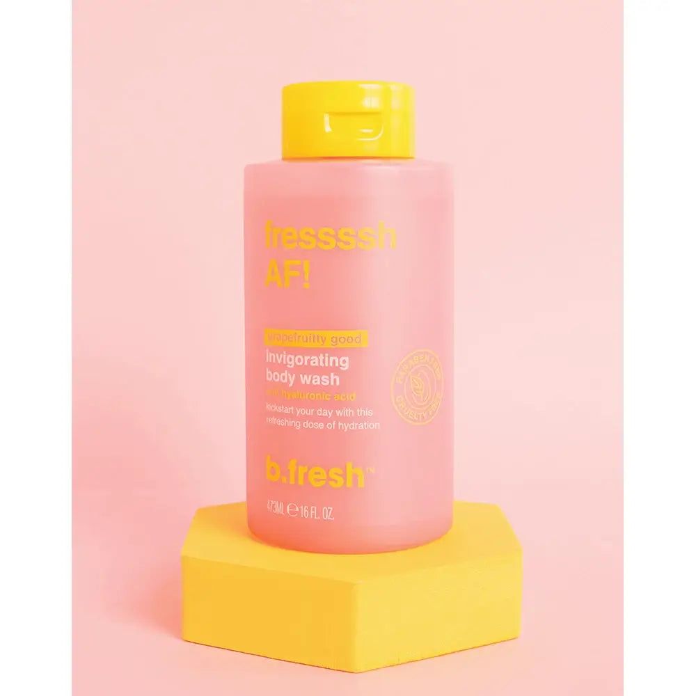 Flacone di gel doccia rosa con tappo giallo su piedistallo giallo. Scritta: b.fresh Fressssh AF!