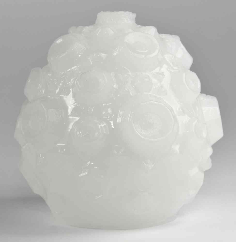 Oggetto bianco strutturato a forma di uovo. Superficie con forme irregolari.