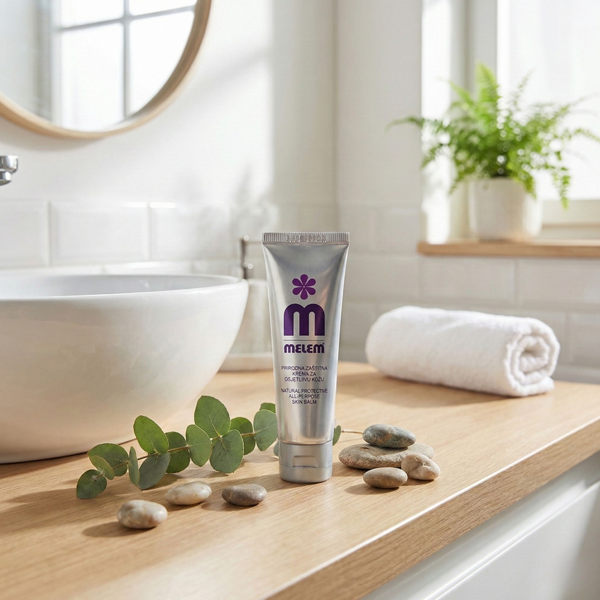 Tubo d'argento con logo viola e scritta MELEM su una superficie di legno. Decorazione: pietre, ramo, asciugamano.