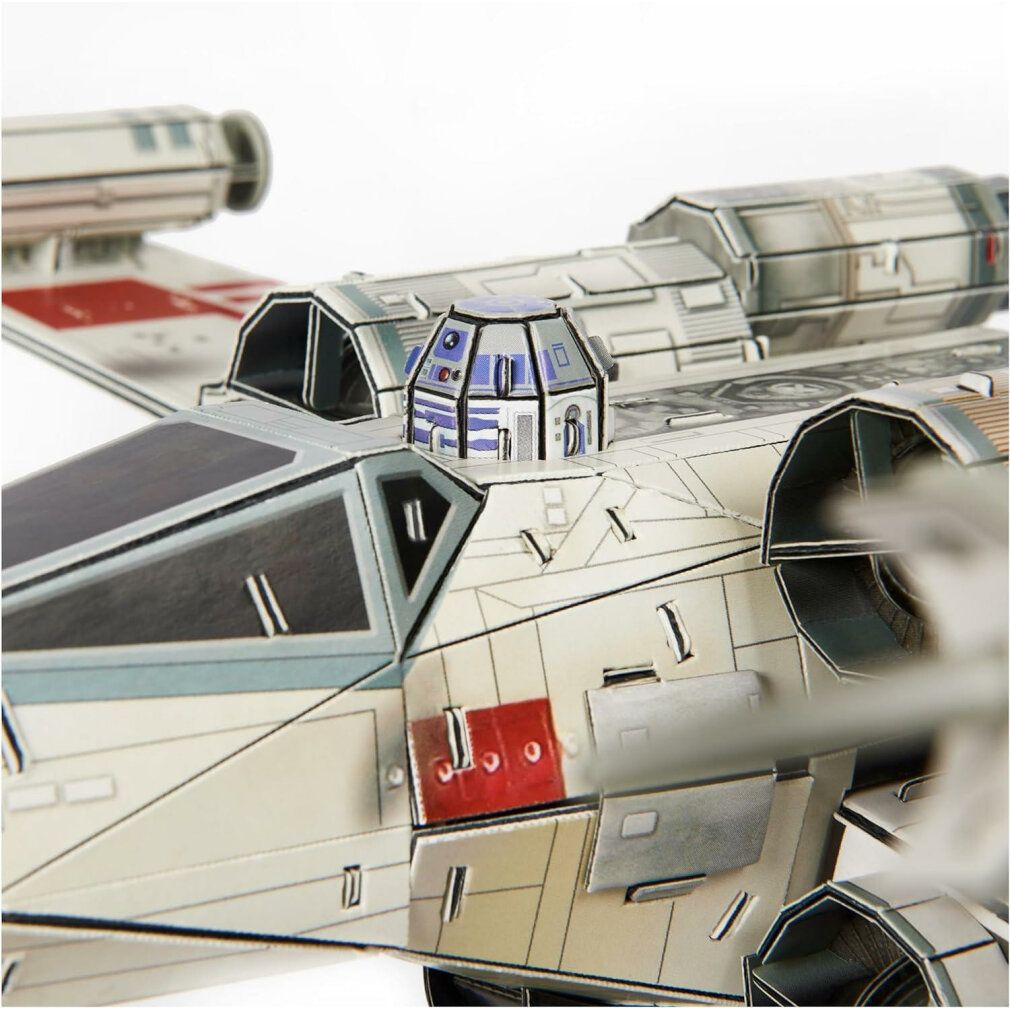 Primo piano dell'abitacolo del modello X-Wing. Dettagli blu e bianchi. Figura di R2-D2 visibile.