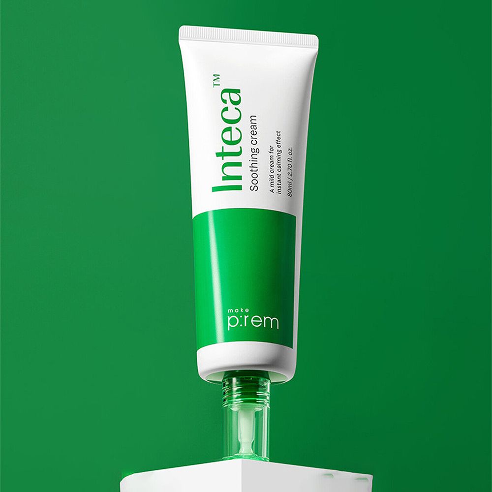 Tubo bianco con fascia verde e scritta 'Inteca Soothing cream'. Marchio MAKE P:REM. Su piedistallo bianco, sfondo verde.