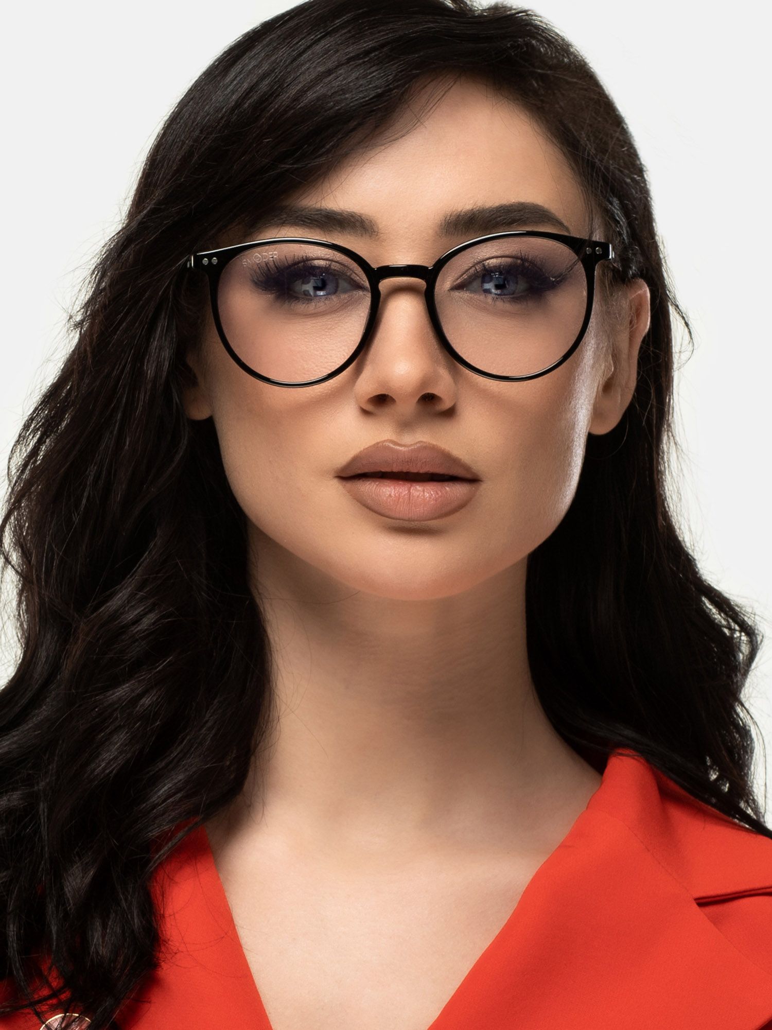 Una donna indossa occhiali neri con lenti rotonde. Gli occhiali sono sul suo viso.