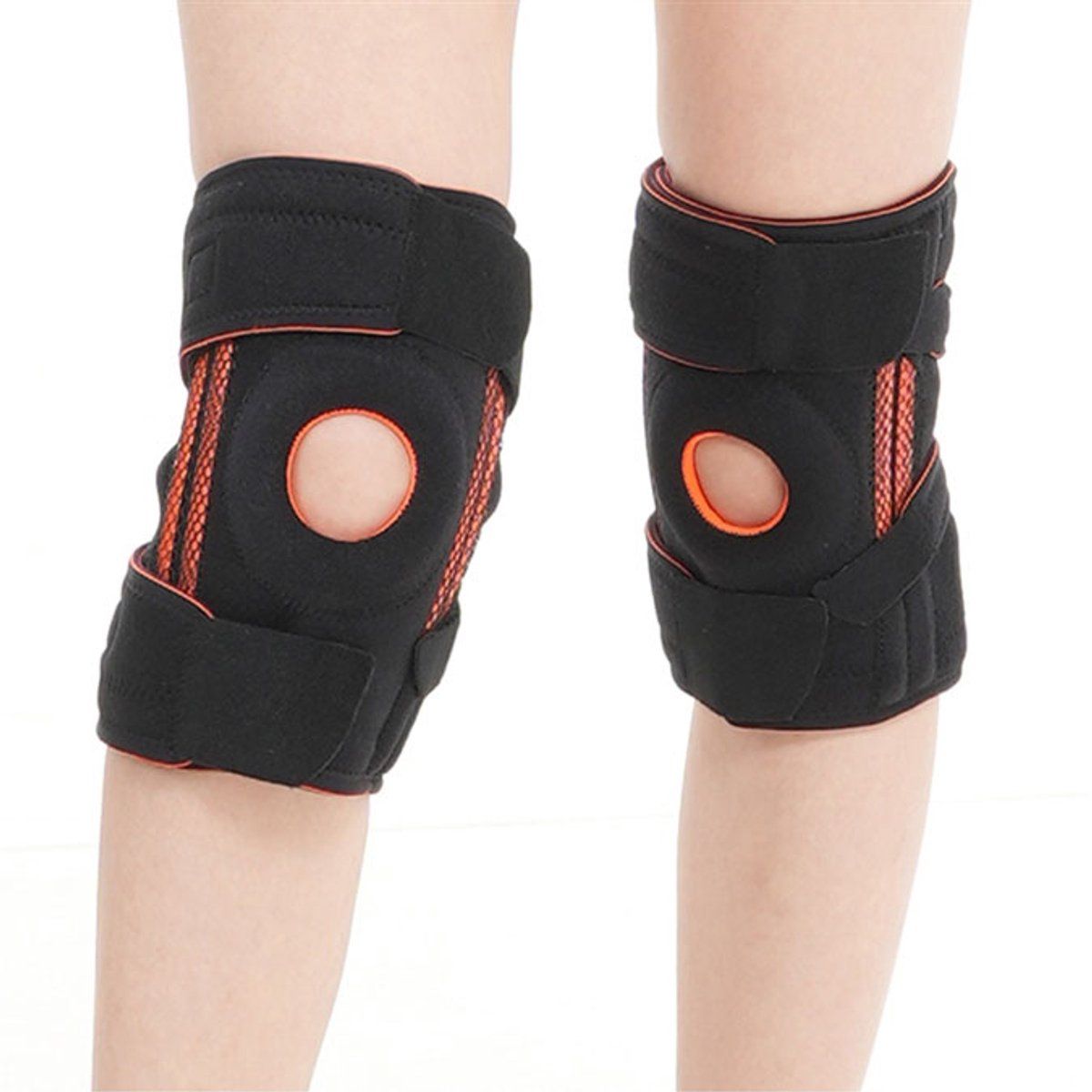 Due ginocchiere nere con dettagli arancioni. Chiusure in velcro e apertura per la rotula. Indossate sulle gambe.