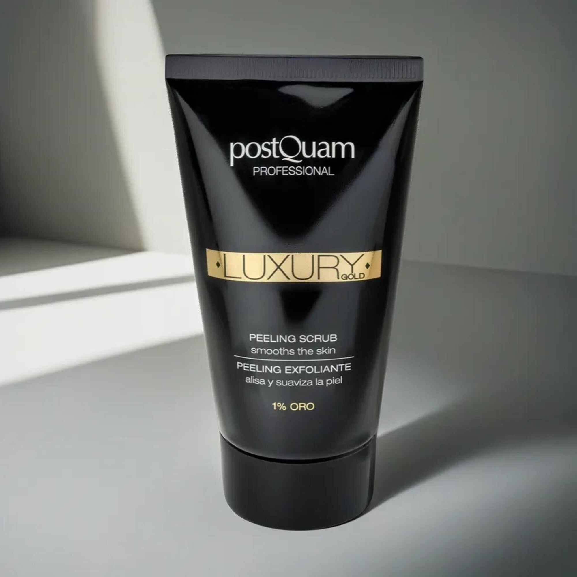 Tubo nero "Postquam Professional Luxury Gold". Testo: Peeling Scrub, 1% Oro. Tappo nero. Su sfondo chiaro.