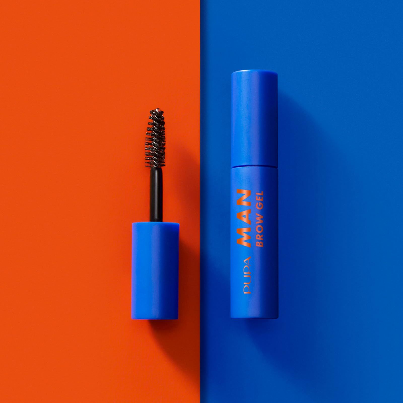 Gel per sopracciglia blu con testo arancione. Su sfondo arancione-blu. Spazzola accanto.