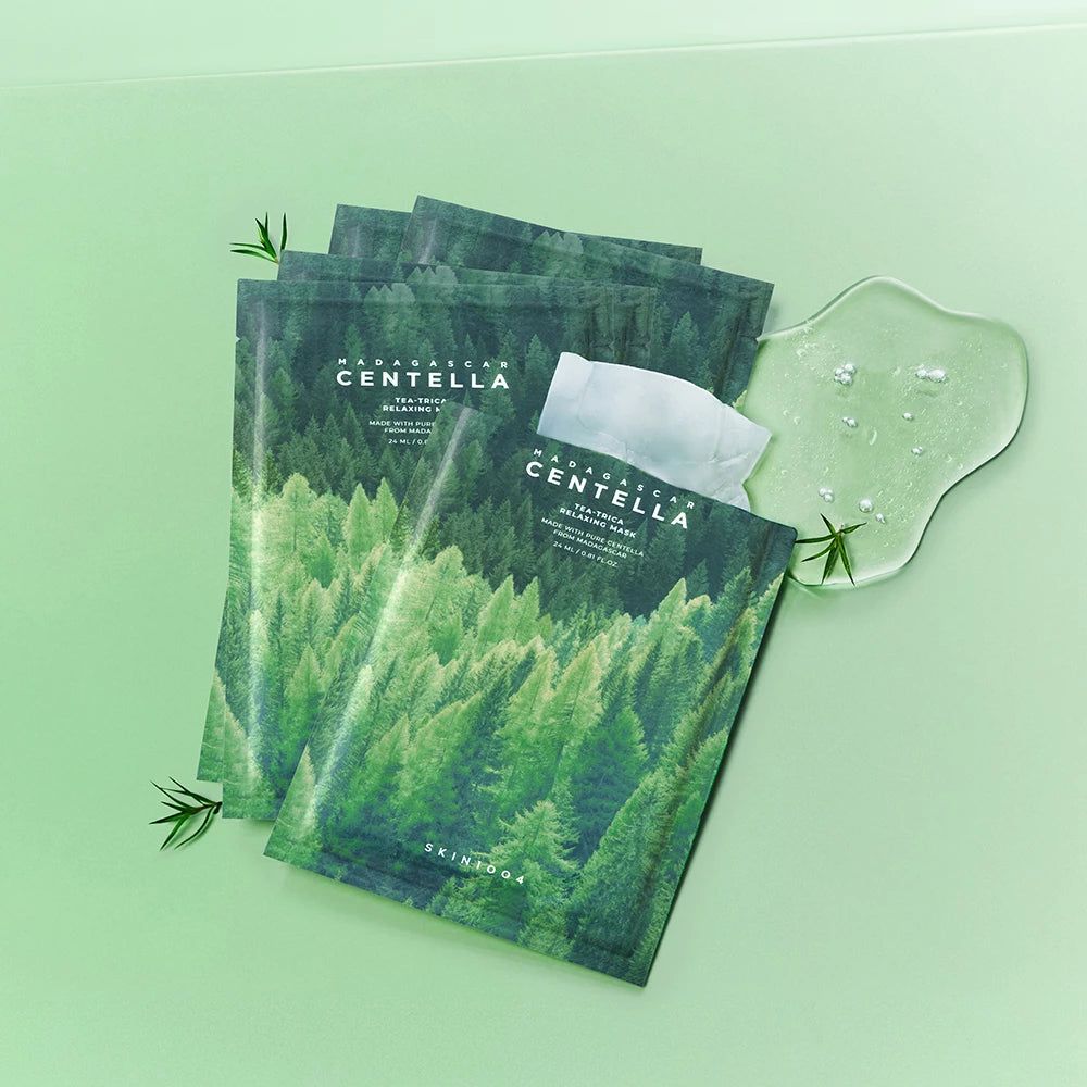 Diverse confezioni di maschere con motivo forestale e nome del prodotto. Accanto, una massa di gel trasparente e foglie. Testo: Madagascar Centella.