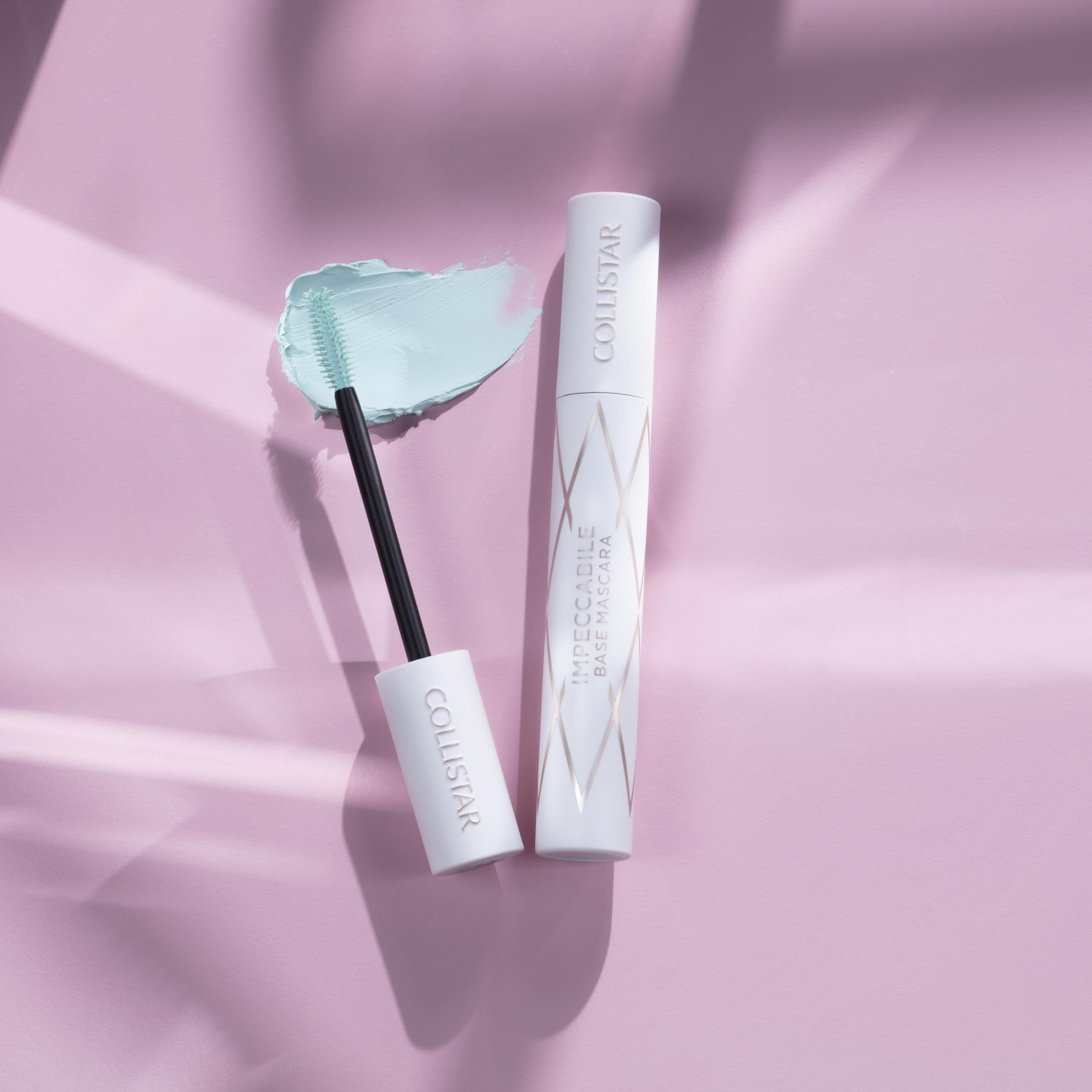 Primer mascara con spazzola e prodotto. Contenitore bianco con motivo dorato. Spazzola con prodotto.