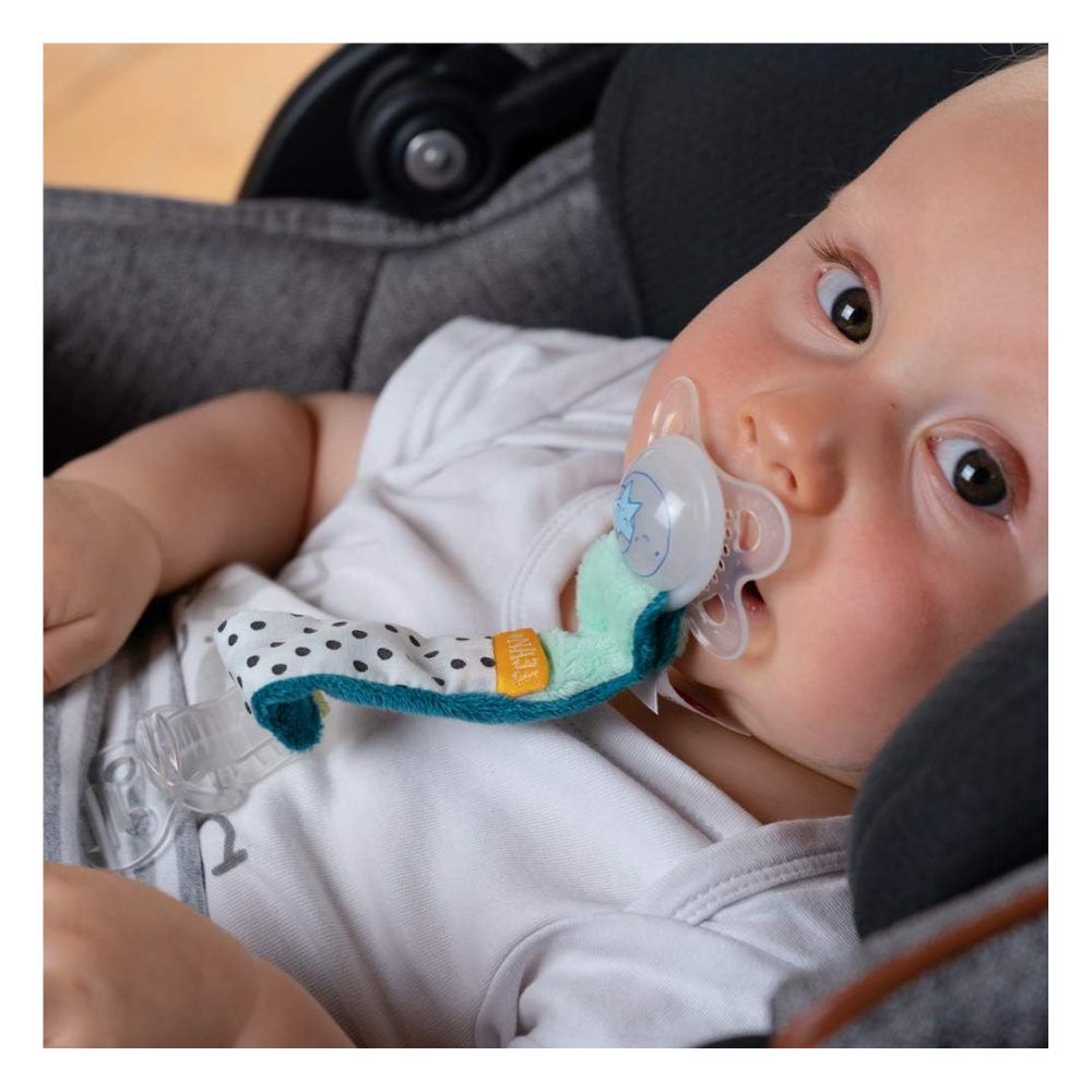 Bambino con ciuccio e portaciuccio Minze. Bambino in seggiolino auto. Ciuccio in bocca.