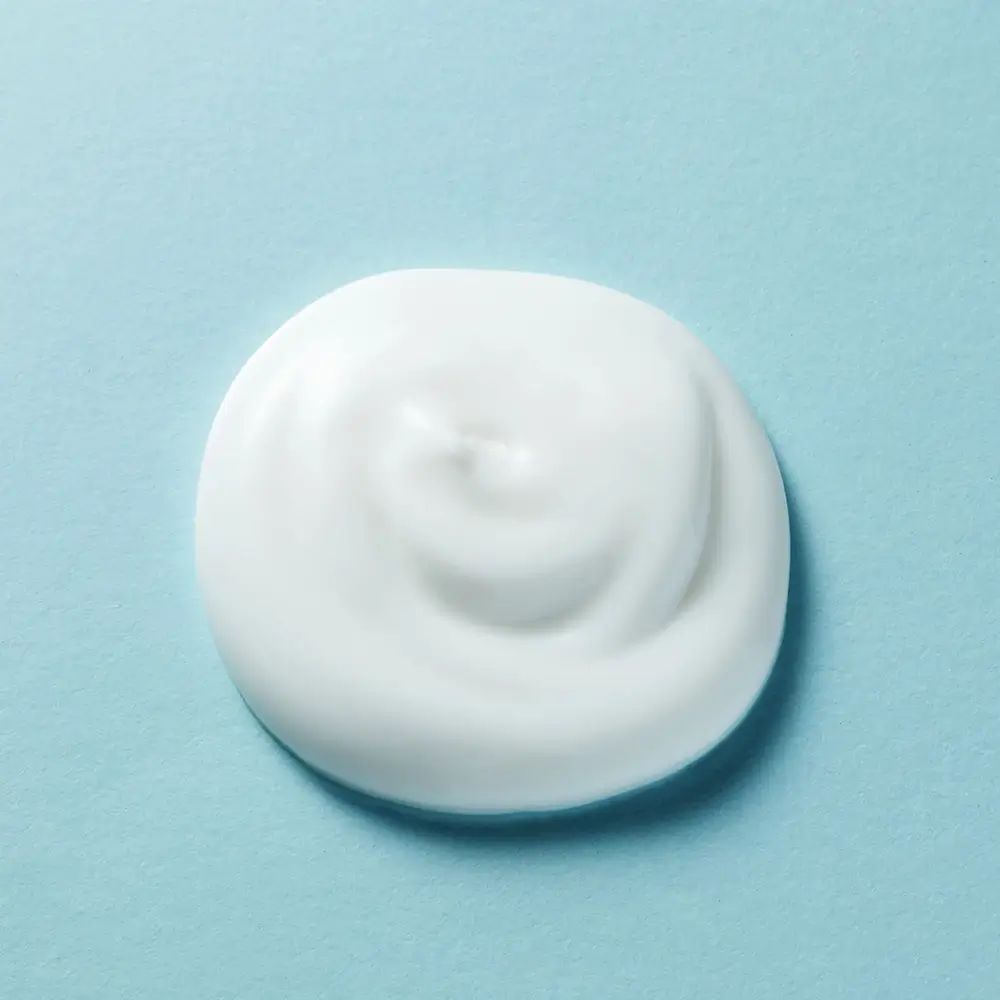 Primo piano di una goccia bianca a spirale. Sfondo: azzurro.