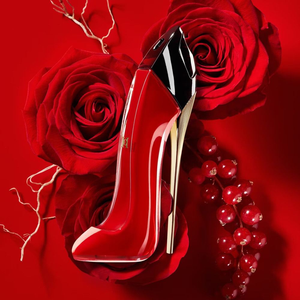 Flacone di profumo a forma di scarpa rossa con rose e bacche.
