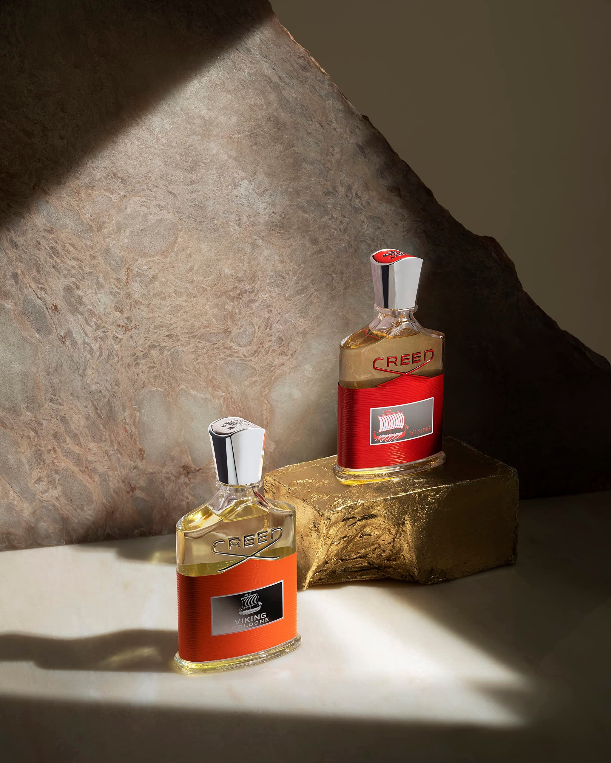 Due flaconi di profumo su una superficie dorata. Sull'etichetta è scritto "VIKING". I flaconi hanno tappi argentati.