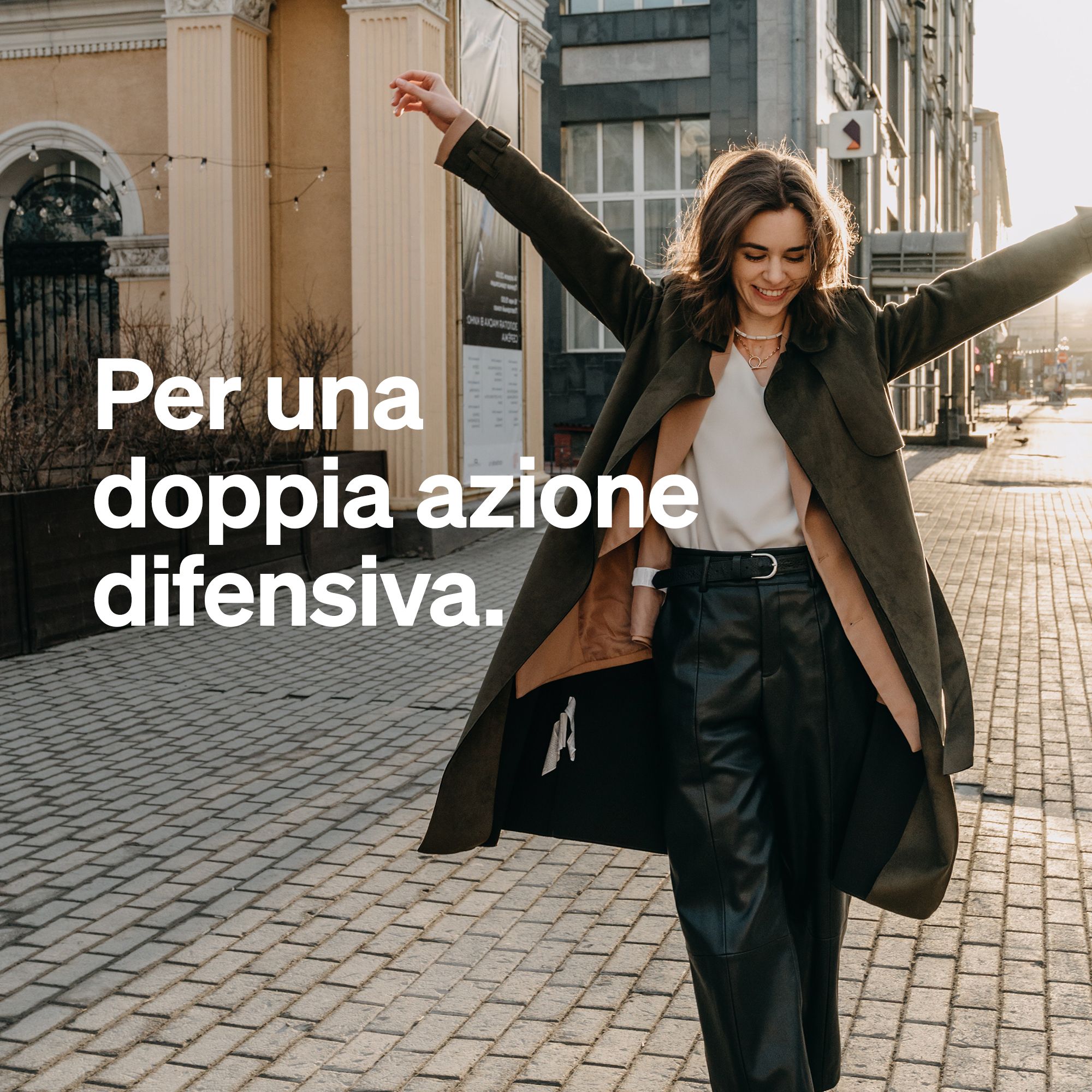 Donna con braccia aperte in un ambiente urbano.