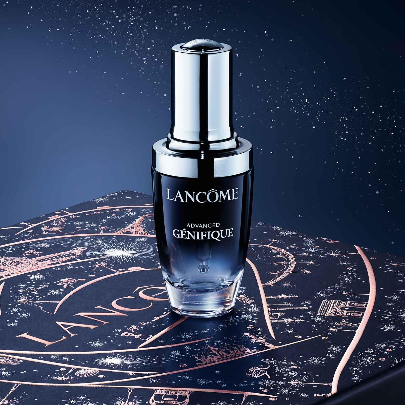 Siero Lancôme Advanced Génifique. Flacone nero, tappo argento. Posizionato su confezione regalo con motivo stellato.