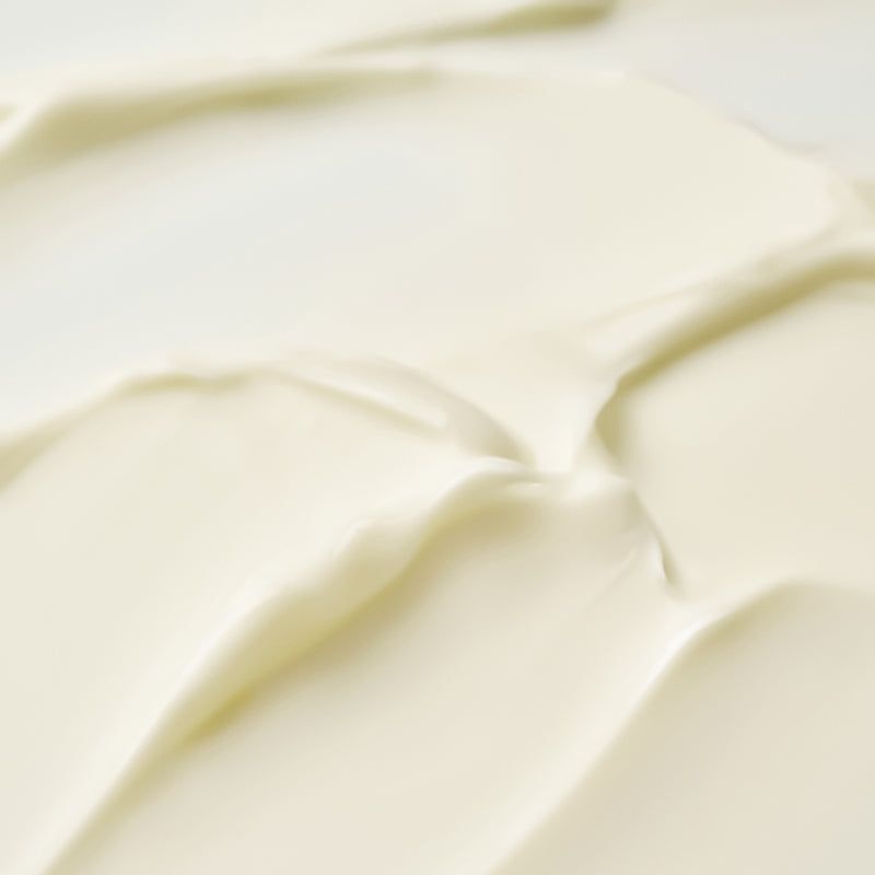 Primo piano della crema. Crema color crema con texture liscia. Motivi ondulati.