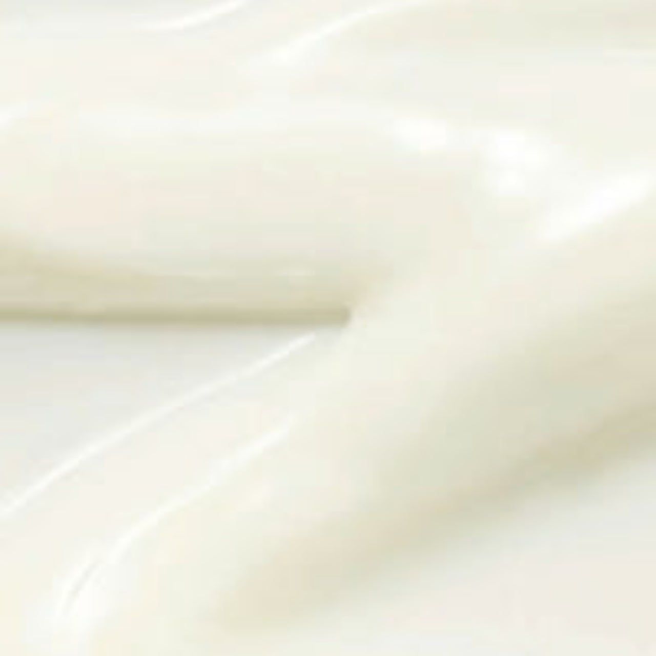 Primo piano di una sostanza cremosa bianca con superficie lucida.