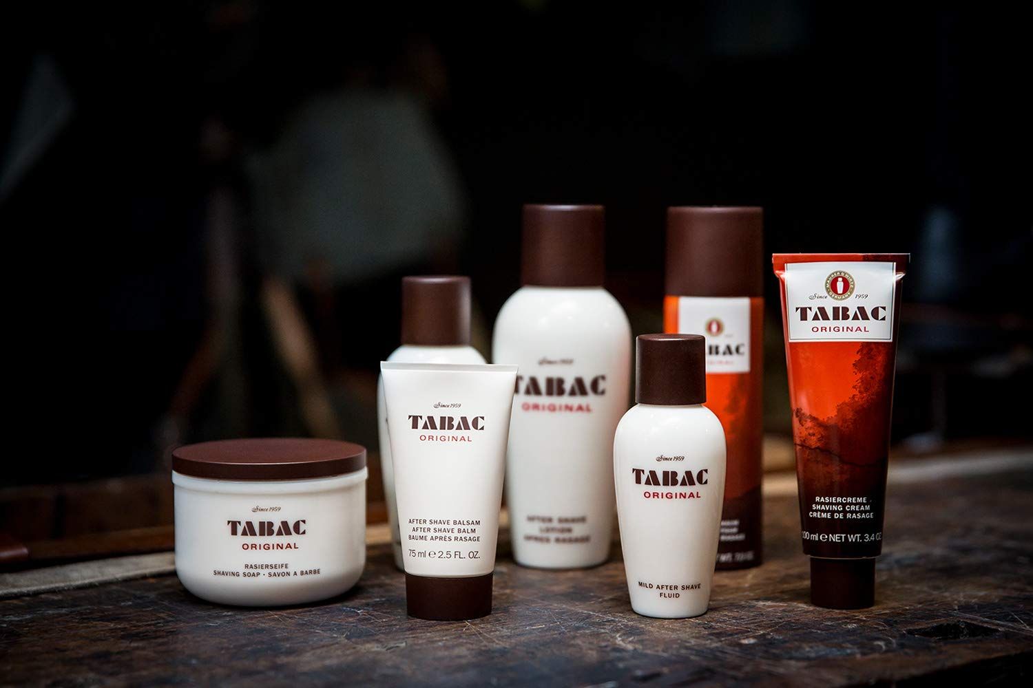 Vari prodotti con tappi marroni ed etichetta bianca. Scritta: TABAC ORIGINAL. Dopobarba, crema da barba, ecc.