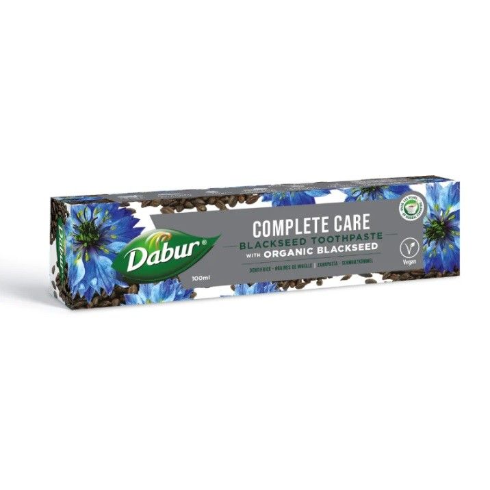 Scatola di dentifricio Dabur Complete Care Nigella con motivo fiordaliso e semi.