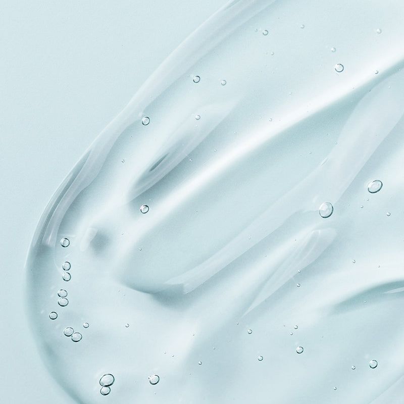 Primo piano di un liquido trasparente con bolle. Nessuna bottiglia visibile.