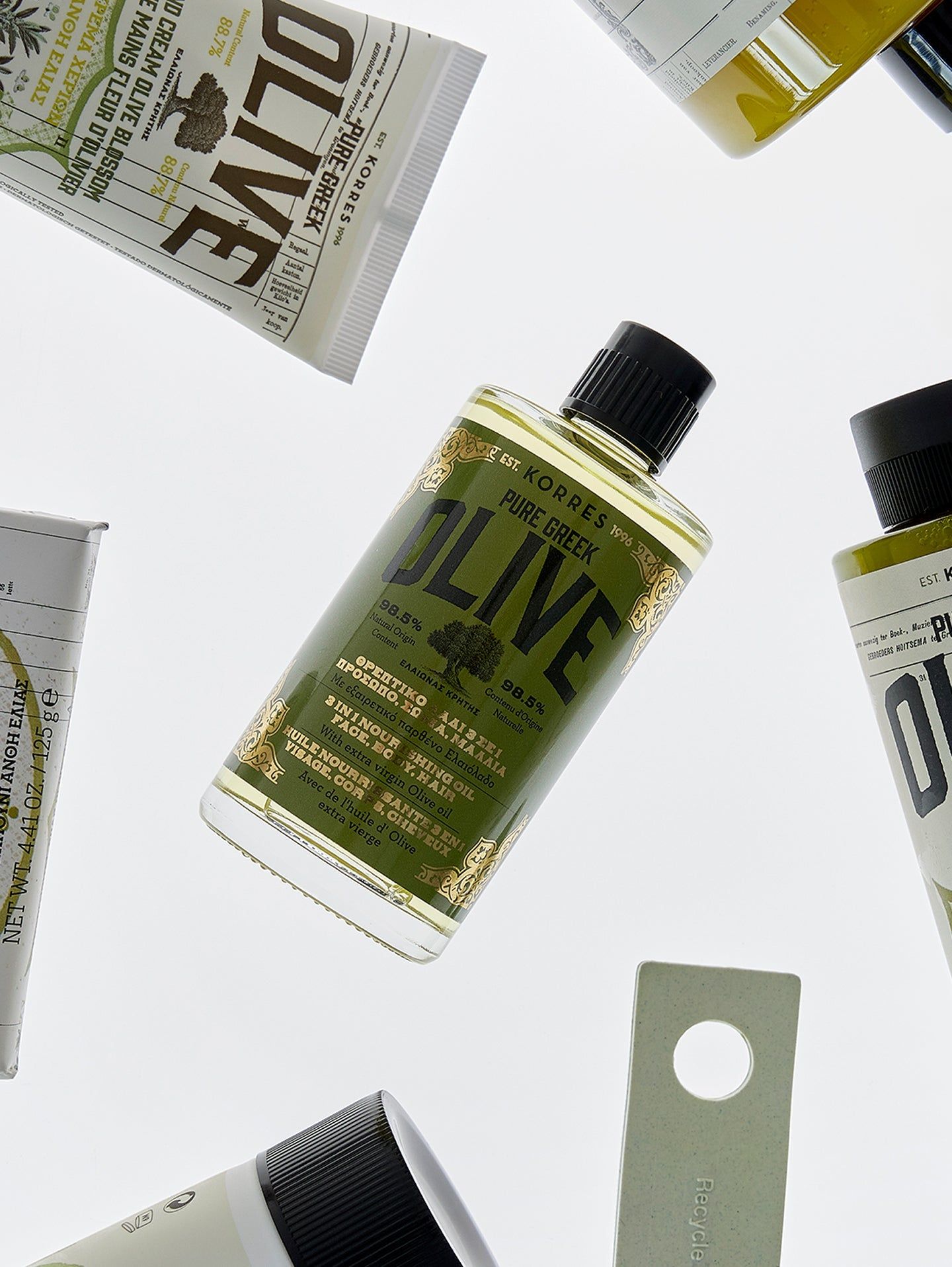Diversi prodotti e confezioni. Prodotto principale: KORRES Pure Greek OLIVE olio. Etichette verde-oro. Tappo nero.