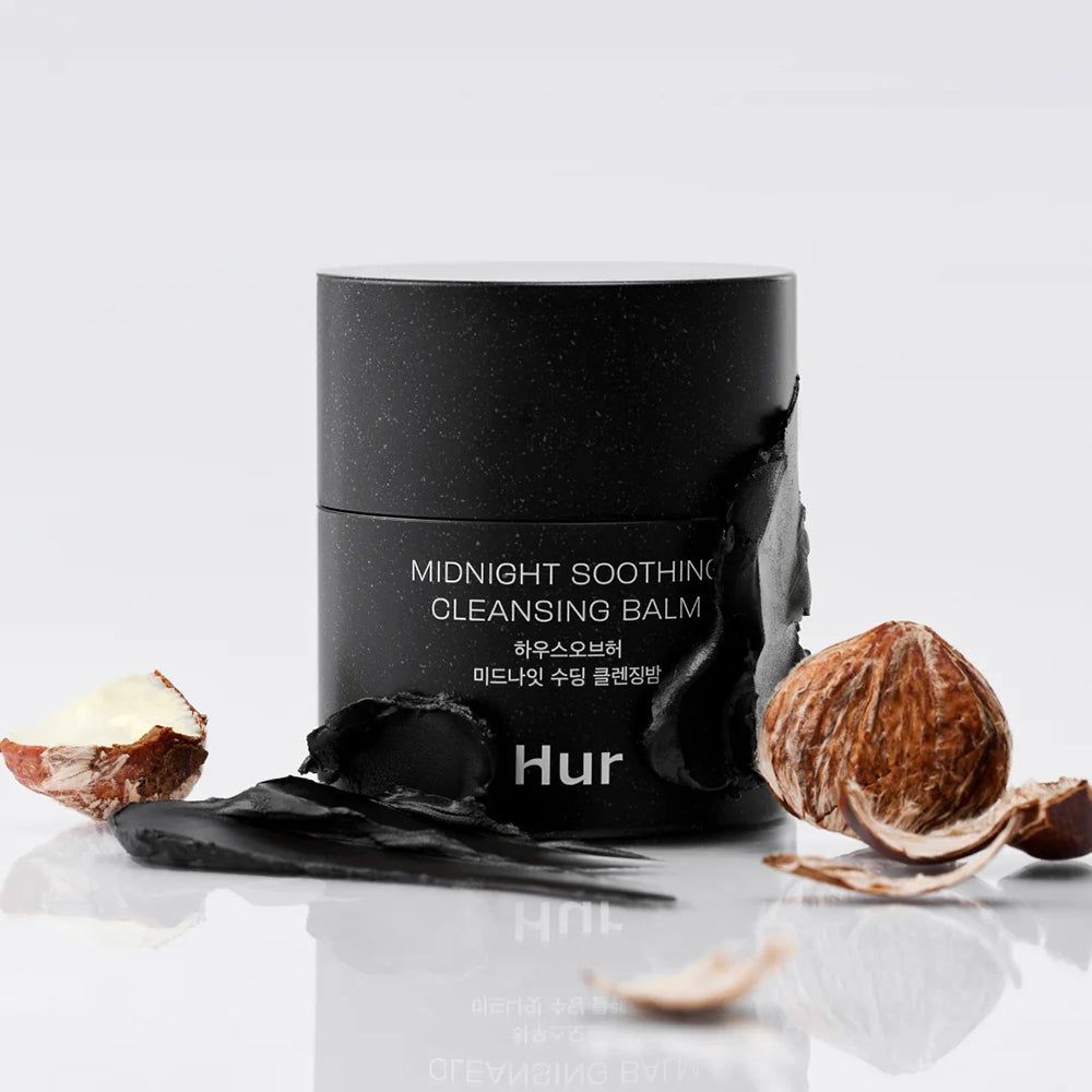 Barattolo nero con scritta: Midnight Soothing Cleansing Balm. Marchio: Hur. Circondato da ingredienti. Sfondo bianco.
