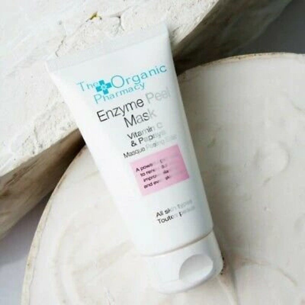 Tubo bianco. Testo: Enzyme Peel Mask, Vitamina C & Papaya, per tutti i tipi di pelle. Su fondo in legno e pietra.