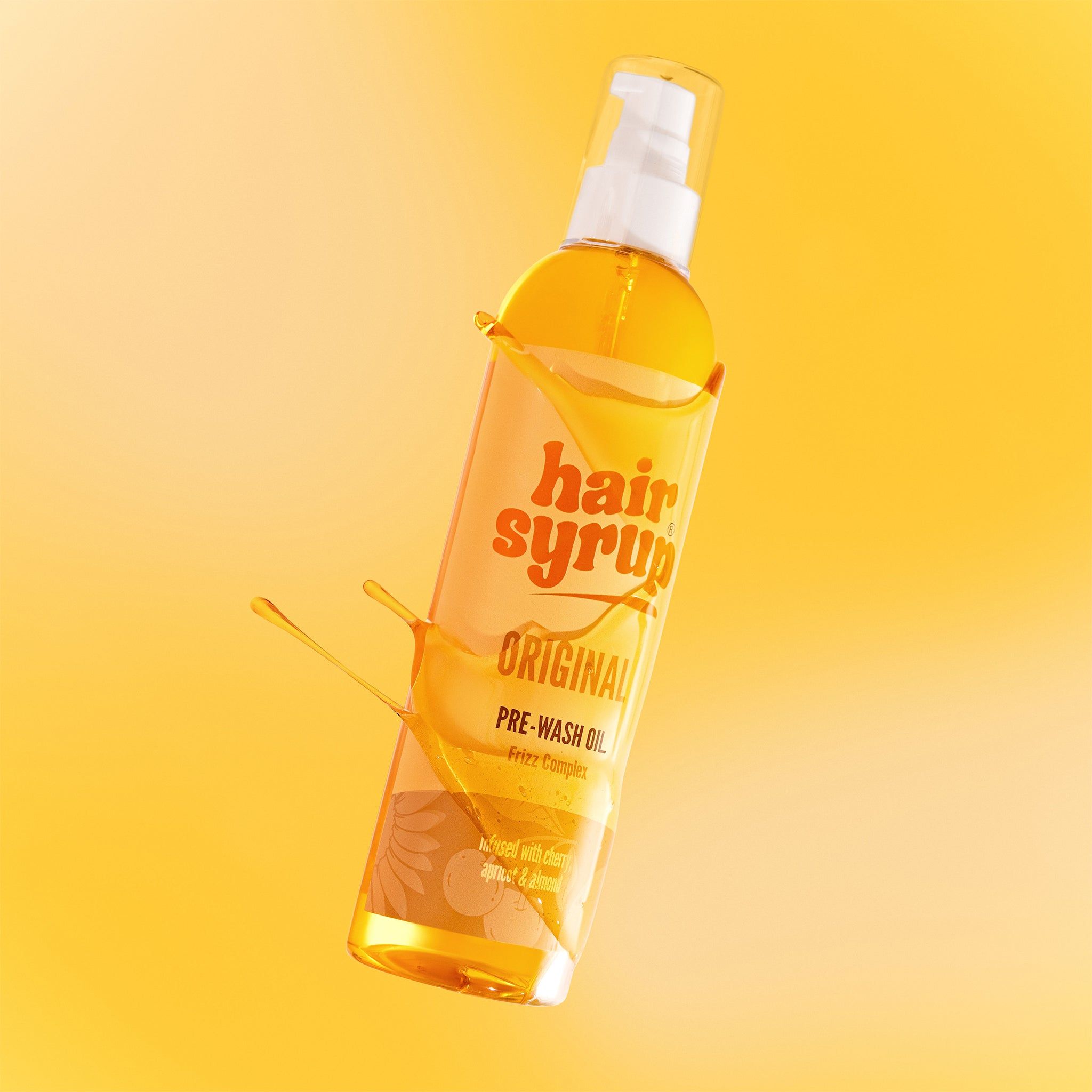 Bottiglia di Hair Syrup The Original con schizzi di liquido. Sfondo giallo.